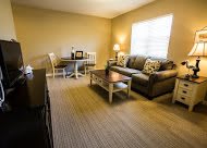 A cozy living room with a sofa, coffee table, and dining area.
