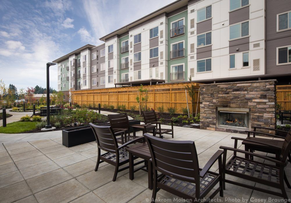 Modern apartment complex with outdoor patio seating.