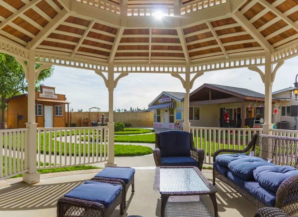 A cozy outdoor seating area under a gazebo, overlooking a well-maintained garden.