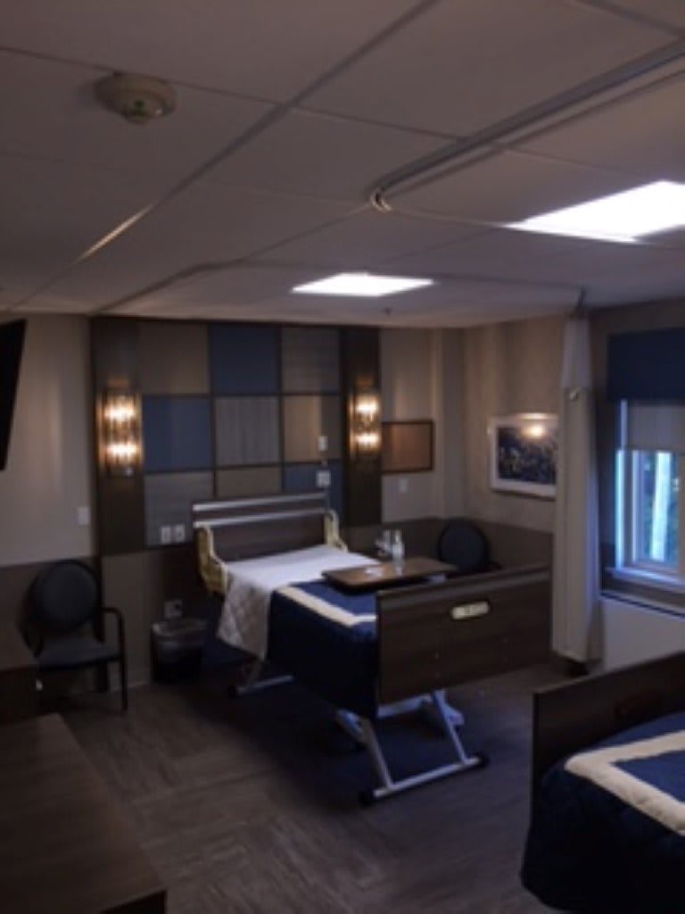 A well-furnished hospital room with a bed and modern amenities.