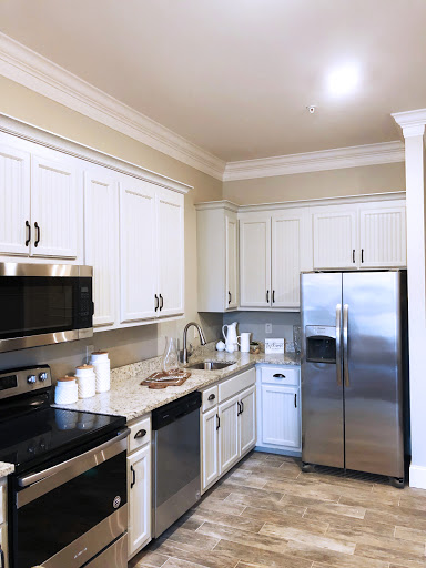 A modern kitchen featuring sleek white cabinetry and stainless steel appliances.