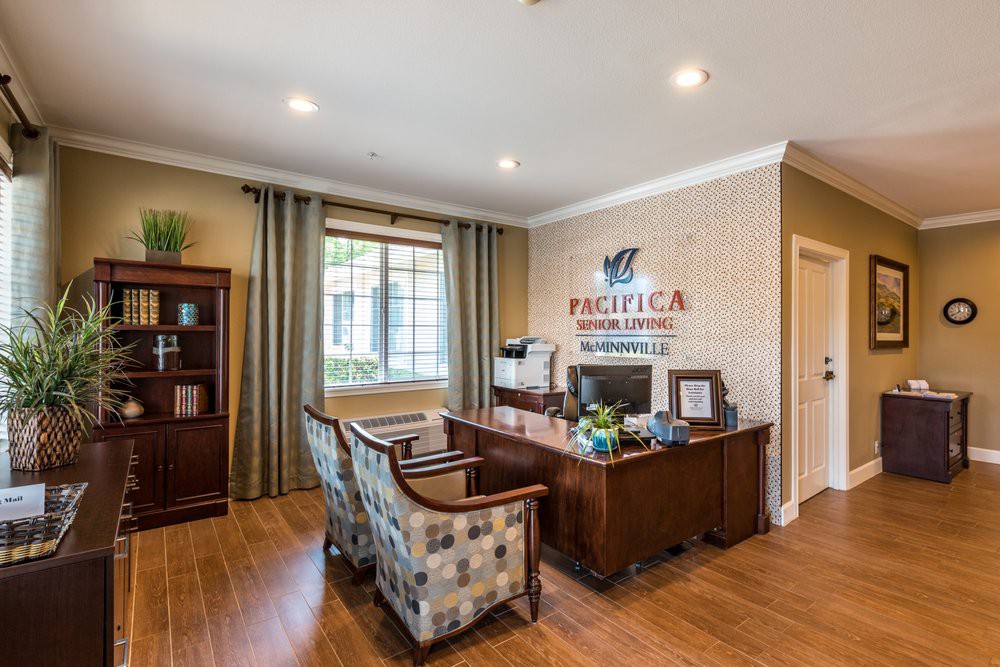 A well-organized office space with a desk, chairs, and a window providing natural light.