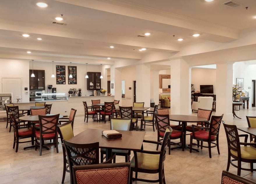 A spacious indoor cafe with a variety of seating arrangements and warm lighting.