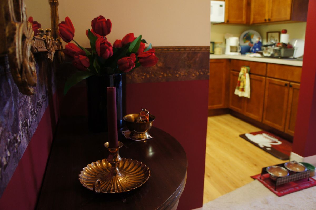 A cozy interior view with a decorative table setting and a glimpse into the kitchen.