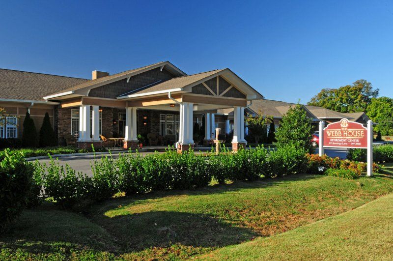 A well-maintained building with a landscaped garden and a welcoming entrance under a clear blue sky.
