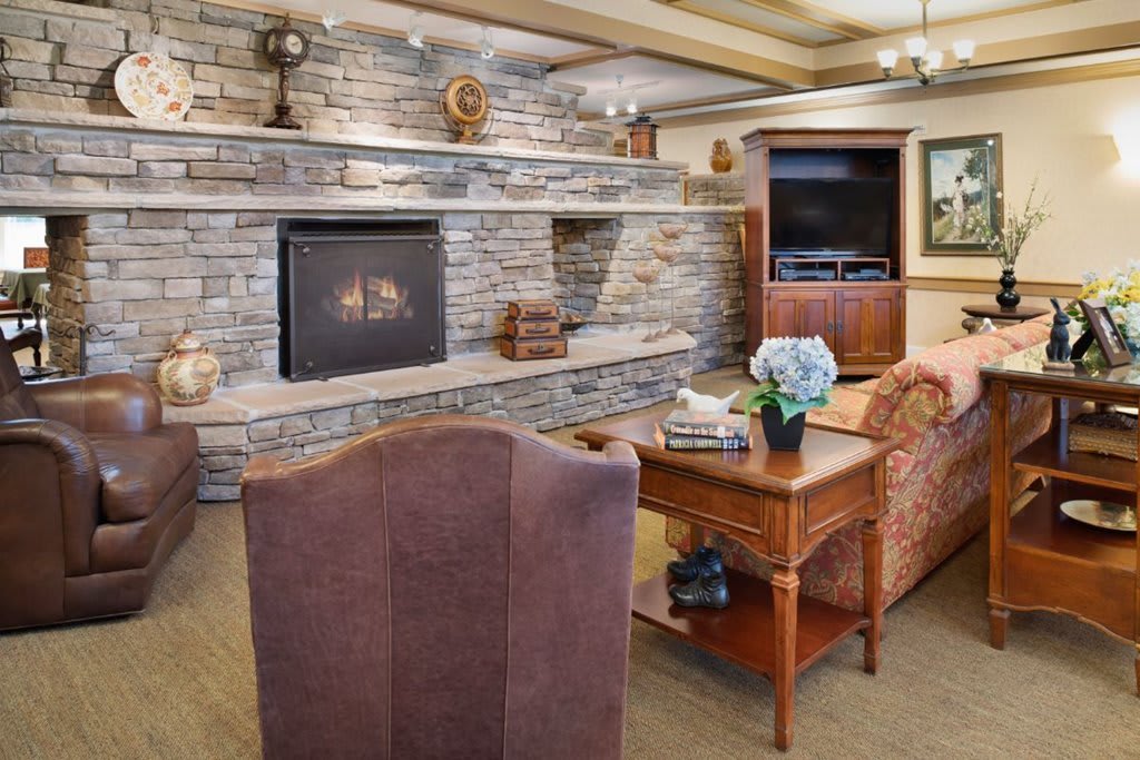 A cozy living room with a stone fireplace and comfortable seating.