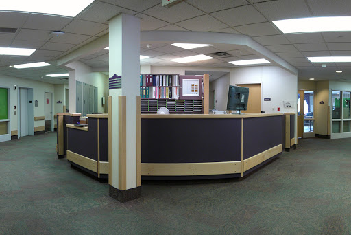 A panoramic view of a modern reception area in an office, showcasing the front desk and workspace.