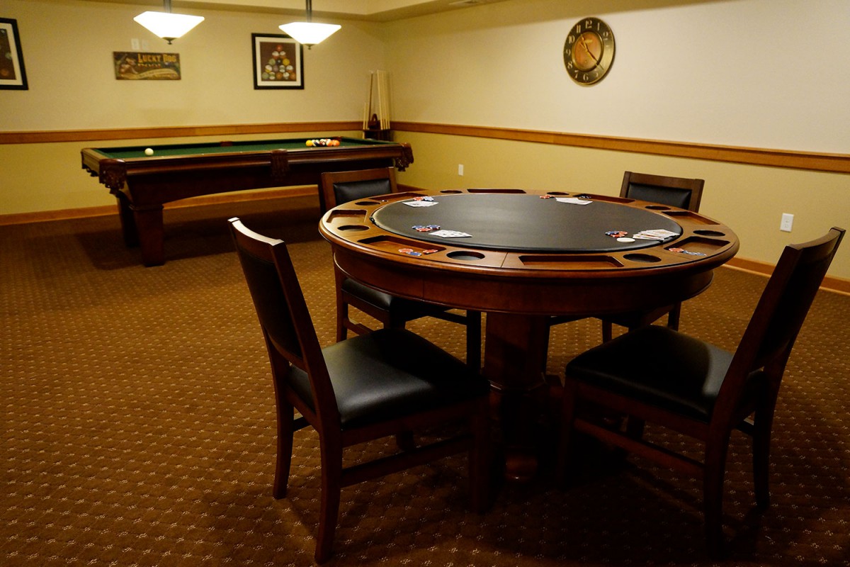 A cozy recreation room featuring a poker table and seating.