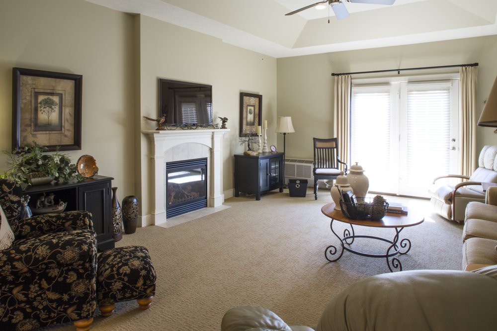 A cozy living room with a fireplace and TV, decorated with elegant furniture.