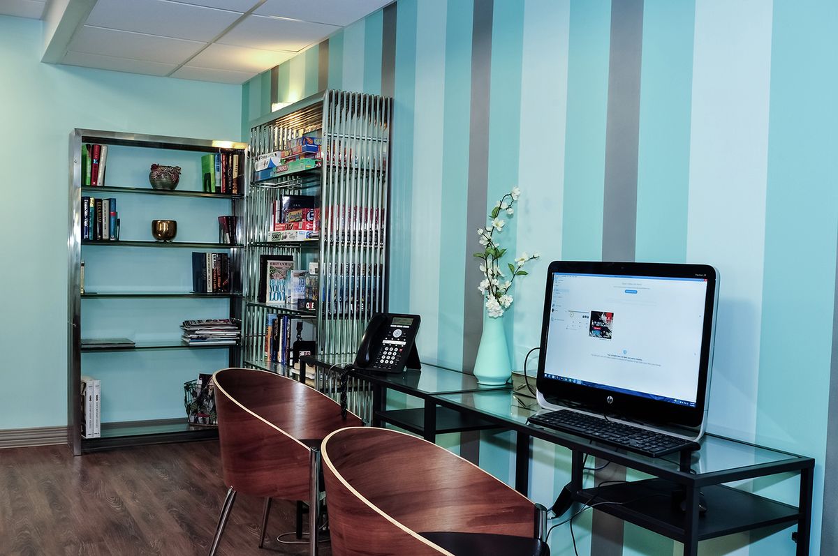 A modern office workspace with a computer, shelves, and stylish decor.