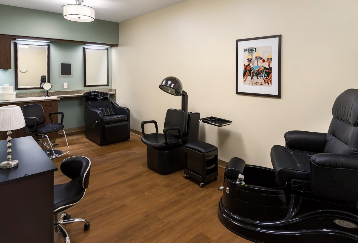 A well-equipped hair salon interior featuring chairs, a sink, and a hair dryer.