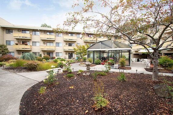 A residential building with a landscaped garden and greenhouse.