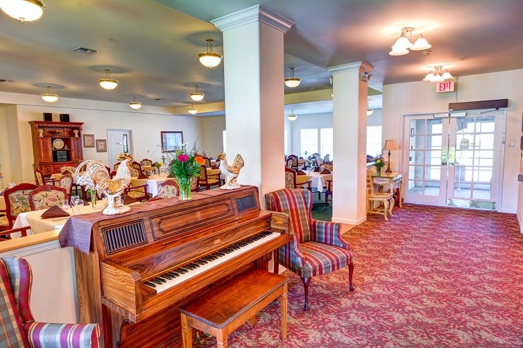 A spacious dining area featuring a piano and comfortable seating arrangements.
