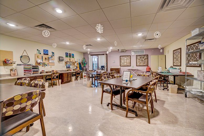 A cozy dining area with neatly arranged tables and chairs, decorative lighting, and a welcoming atmosphere.