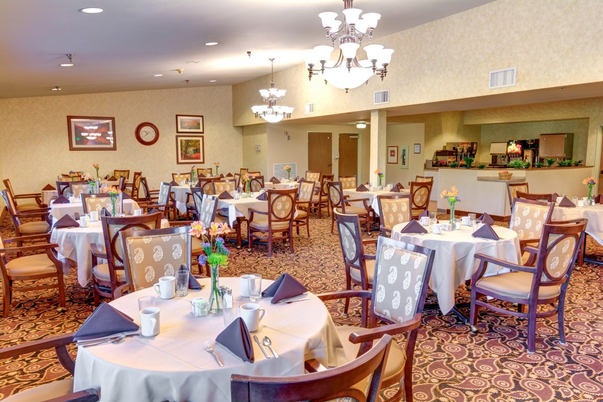 A spacious and elegantly decorated dining area with neatly arranged tables and chairs.
