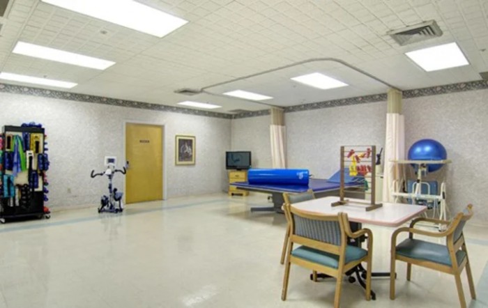 An empty hospital rehabilitation room equipped with therapy and exercise equipment.