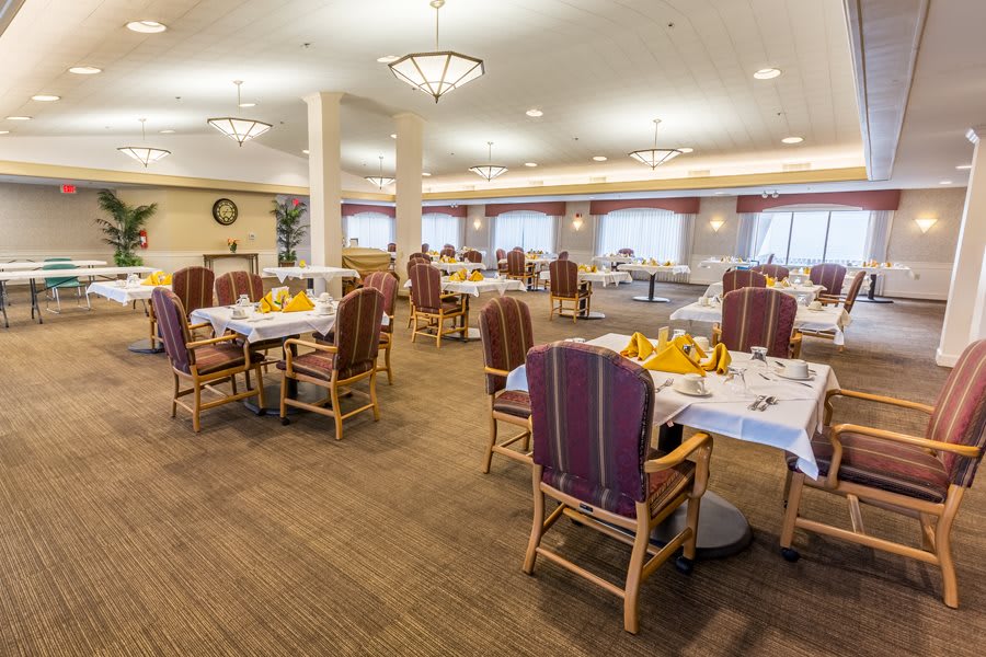 A spacious and elegantly decorated dining area with neatly arranged tables and chairs.