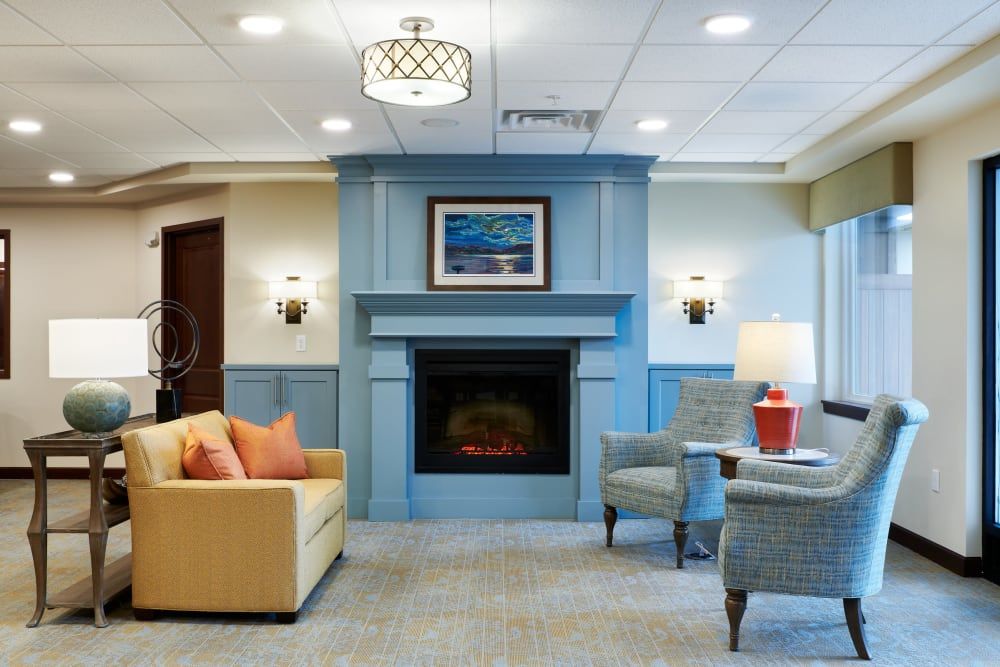 A cozy living room featuring a blue fireplace, comfortable seating, and modern decor.