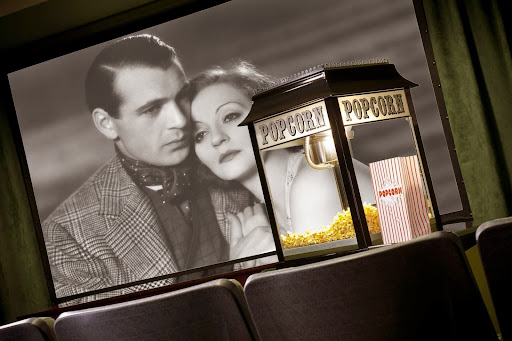 A nostalgic moment captured in a vintage cinema setting, featuring a black and white film scene alongside a classic popcorn machine.