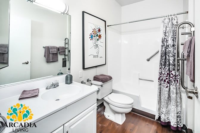 A clean and modern bathroom with a shower, toilet, and sink.