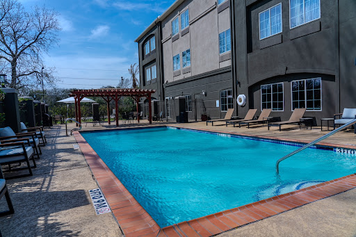 A tranquil hotel pool surrounded by comfortable lounge chairs, perfect for a sunny afternoon.