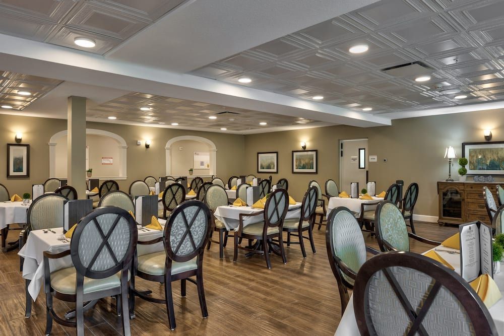 A well-lit dining room with neatly arranged tables and chairs.