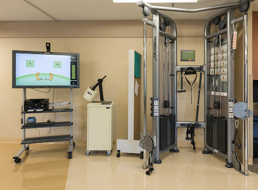 A well-equipped physical therapy room featuring various rehabilitation machines and monitoring systems.