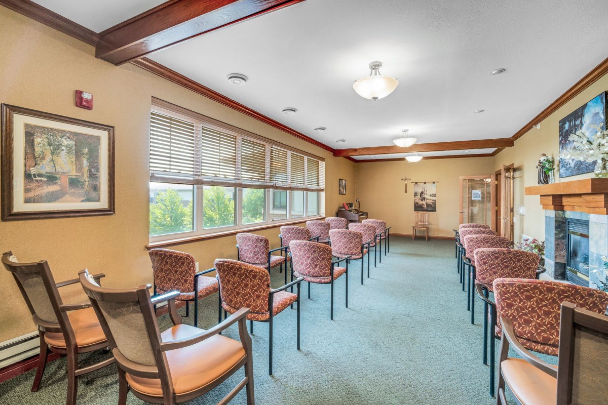 A neatly arranged waiting room with rows of chairs and large windows letting in natural light.