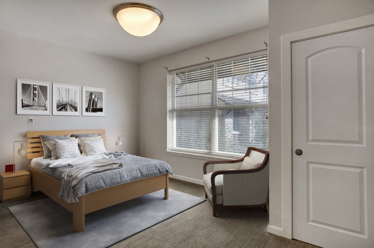 A cozy, well-lit bedroom with modern decor and comfortable furnishings.