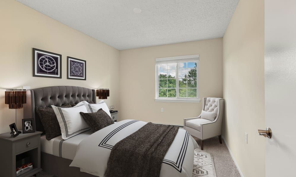 A cozy bedroom with a neatly made bed, featuring neutral colors and a window with a view.