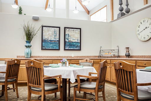 A cozy dining area featuring wooden furniture, tasteful artwork, and a touch of greenery.