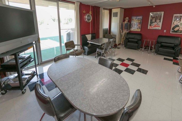 A retro-themed diner interior with vintage furniture and a classic black-and-white checkered floor.