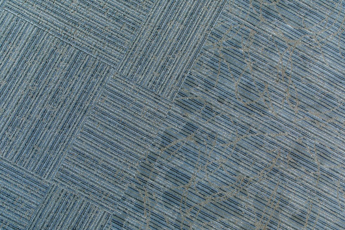 A textured blue carpet with a striped pattern.