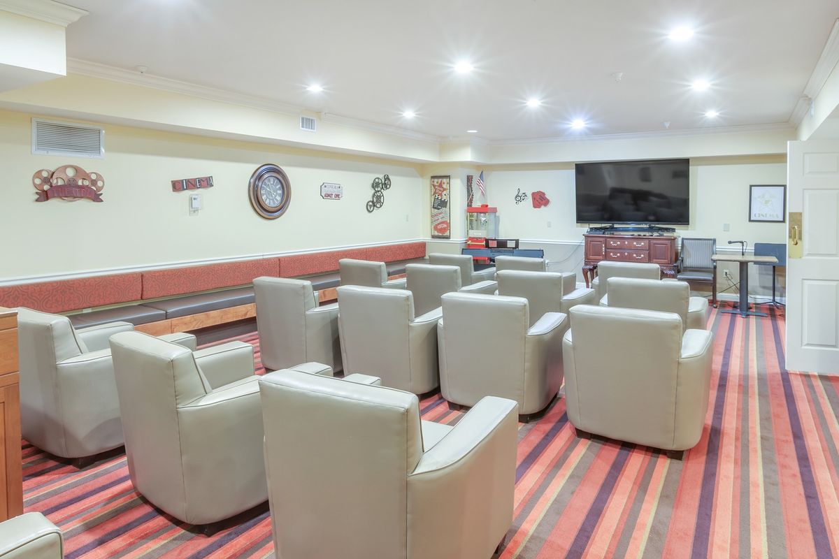 A modern conference room with multiple chairs and a large television for presentations.