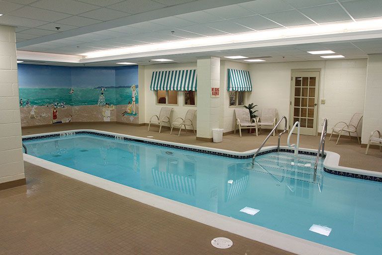 Indoor swimming pool with seating area and mural.