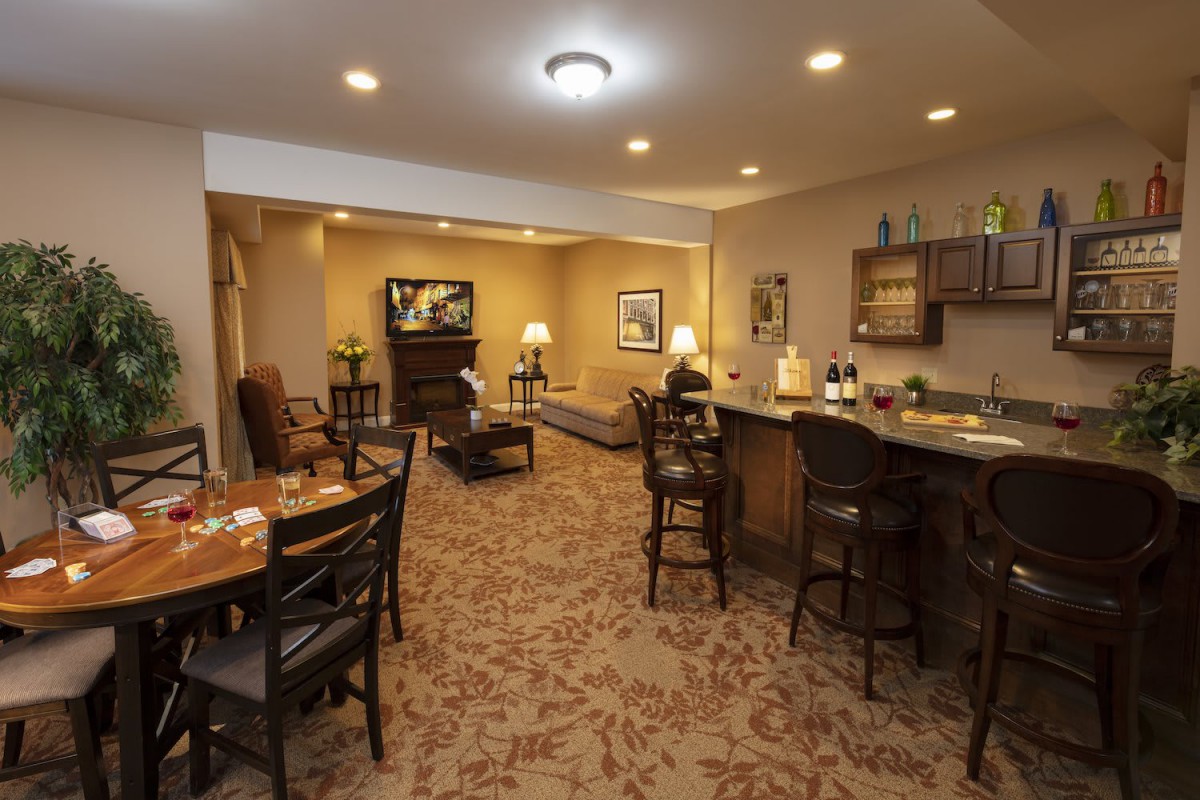 A cozy basement with a bar and seating area.