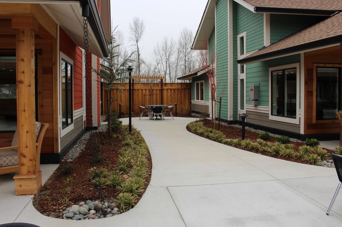 A view of a courtyard between two residential buildings with a paved pathway and landscaped garden.