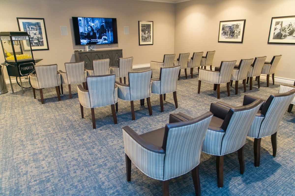 A neatly arranged meeting room with rows of chairs facing a television screen.