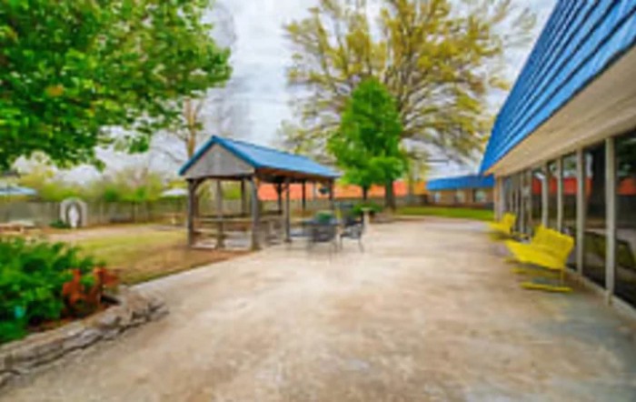 A serene outdoor patio area featuring a gazebo, seating, and lush greenery.