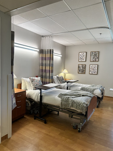 A well-designed patient room in a hospital featuring two beds, curtains for privacy, and tasteful decor.