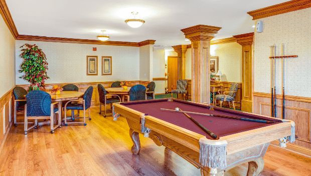 A cozy game room featuring a billiard table and seating area.