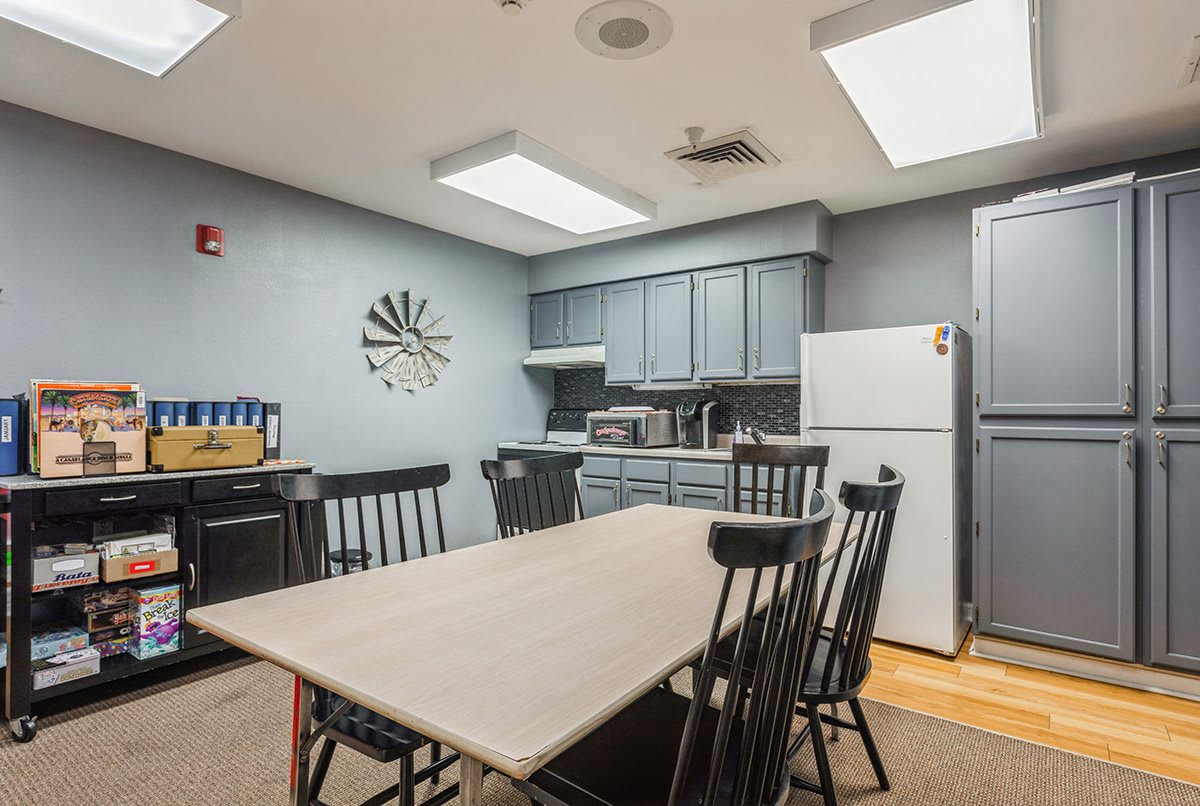 A shared kitchen and dining area featuring a large table with chairs, modern cabinetry, and essential appliances.