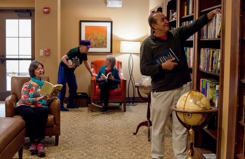 People spending time in a cozy library setting, browsing books and reading.