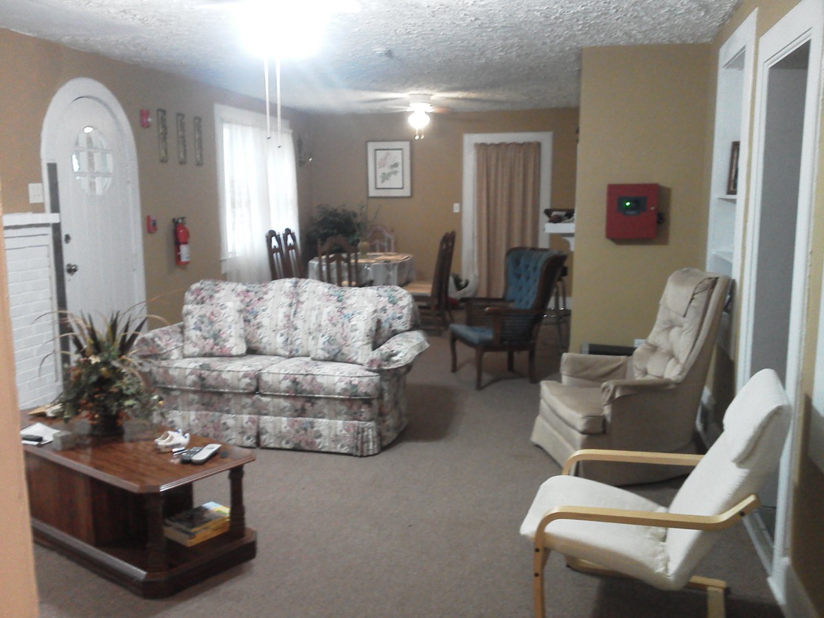 A cozy living room with various furniture pieces including a sofa, chairs, and a table.
