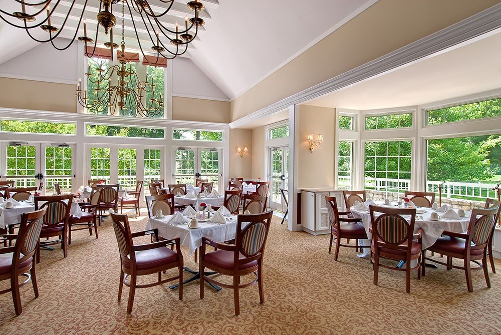A bright dining room with elegant furnishings and large windows allowing natural light to fill the space.