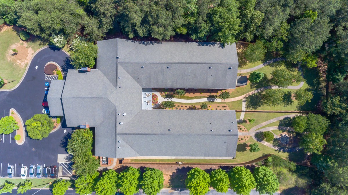 Aerial view of a building surrounded by trees and pathways.