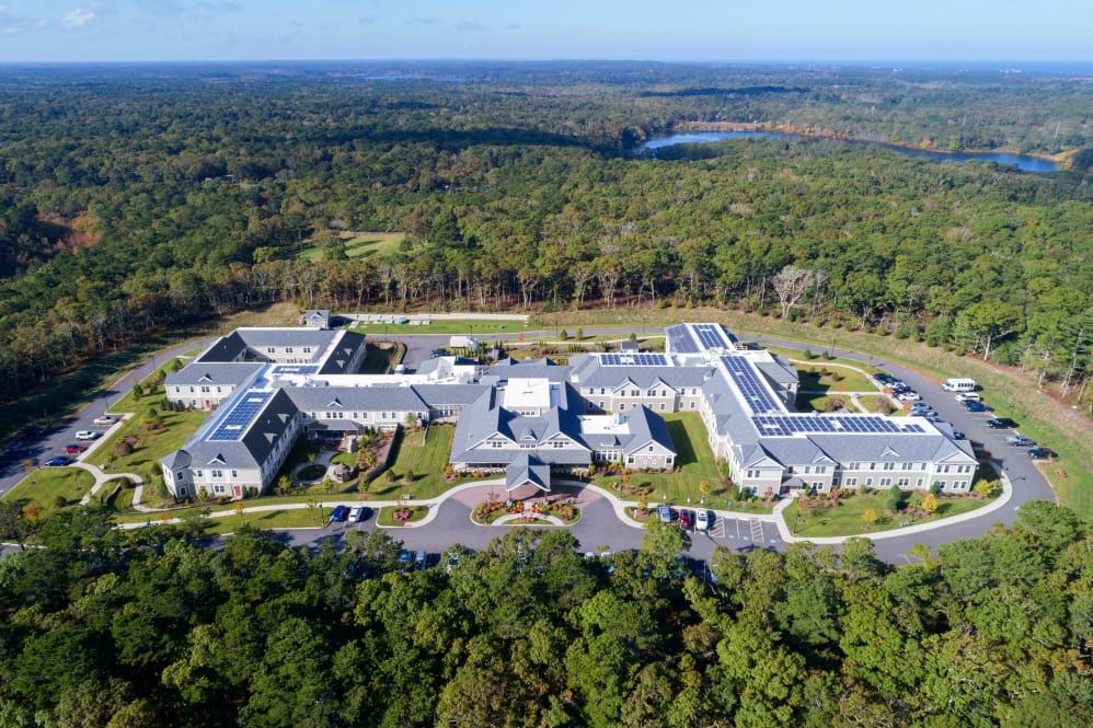 Aerial view of a large building complex surrounded by dense forest.