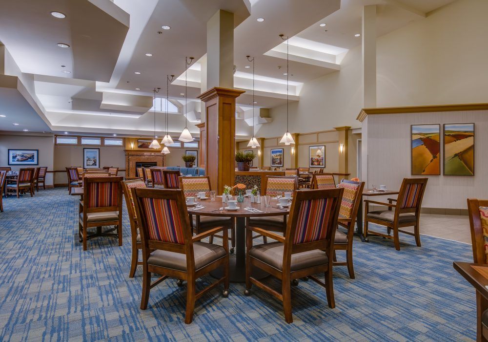 A modern dining area with well-arranged tables and chairs under soft lighting.