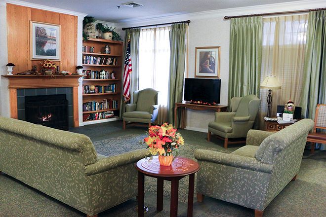 Cozy living room with seating area, fireplace, and bookshelf.