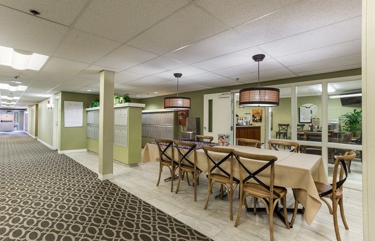 A modern dining area featuring wooden chairs and tables, elegant lighting fixtures, and stylish decor.